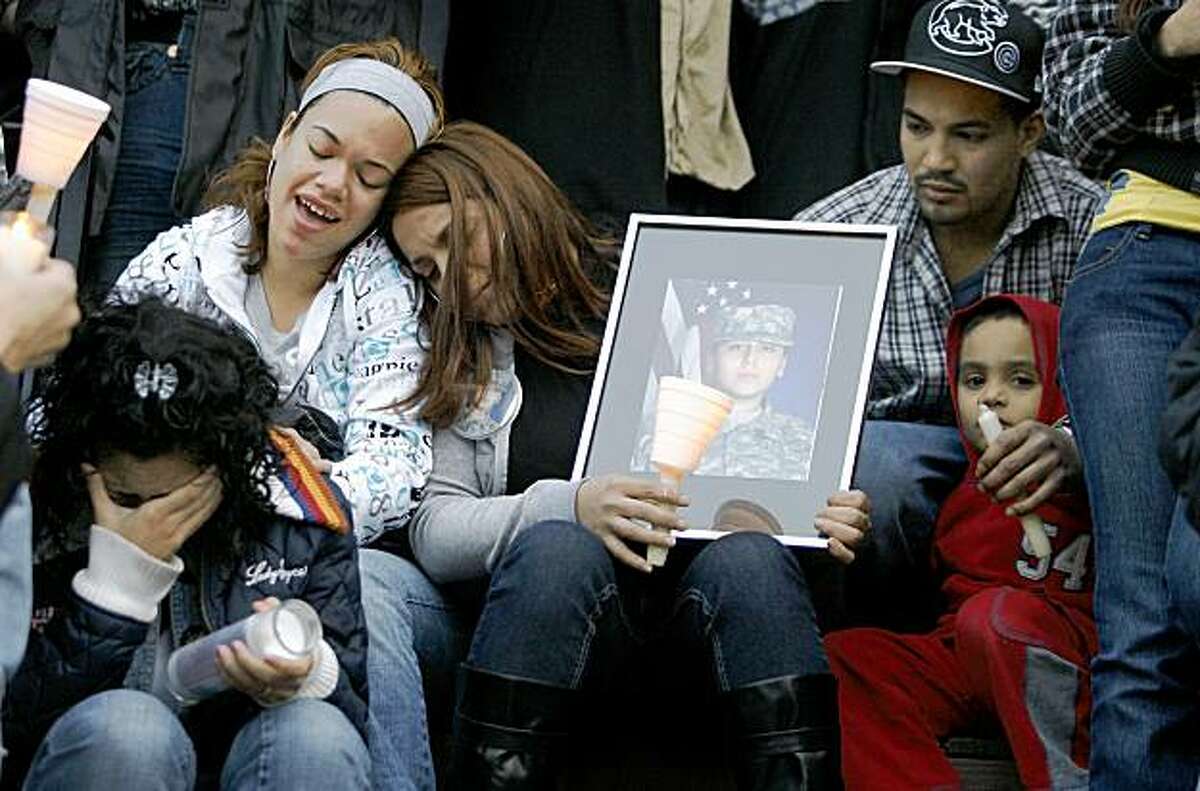 Family members listen to music during a vigil, in front of the home of Pvt. Francheska Velez, 21, in Chicago, Monday, Nov. 9, 2009. Velez, pregnant and preparing to return home, was one of the people killed in the Fort Hood shootings last week. (AP Photo/John Smierciak)