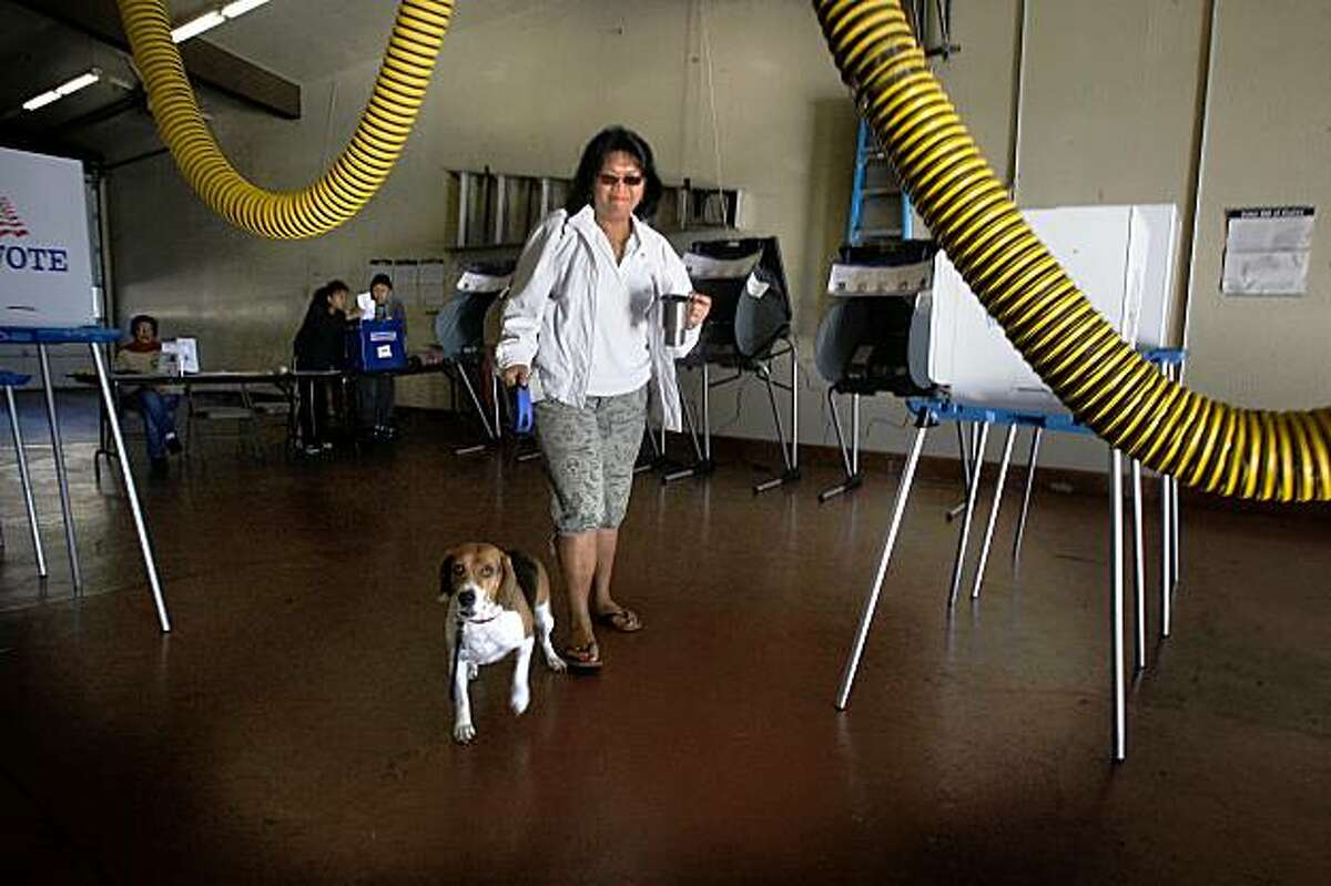 At Fire Station 64 in South San Francisco, Calif., Amy Matthews with her dog, Cosmo, walk in a vote by mail ballot on Tuesday, November 3, 2009. People are voting on a 1 percent hotel tax to help maintain police and fire stations.