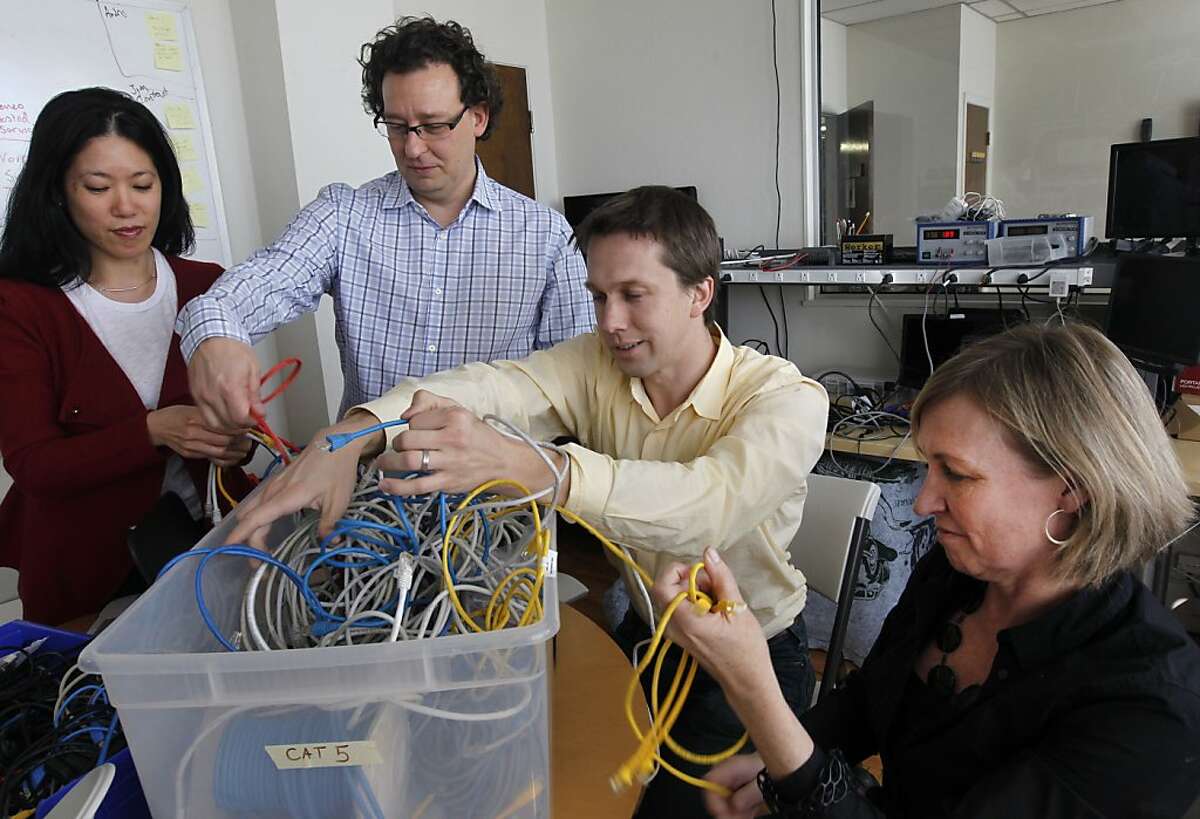 Inveneo company officers Lisa Lin, Mark Summer, Andris Bjornson and Kristin Peterson untangle ethernet cables at the company's South of Market office in San Francisco, Calif. on Friday, Jan. 27, 2012. Inveneo's mission is to set up wireless broadband coverage in developing nations in eastern Africa, Haiti and many others.