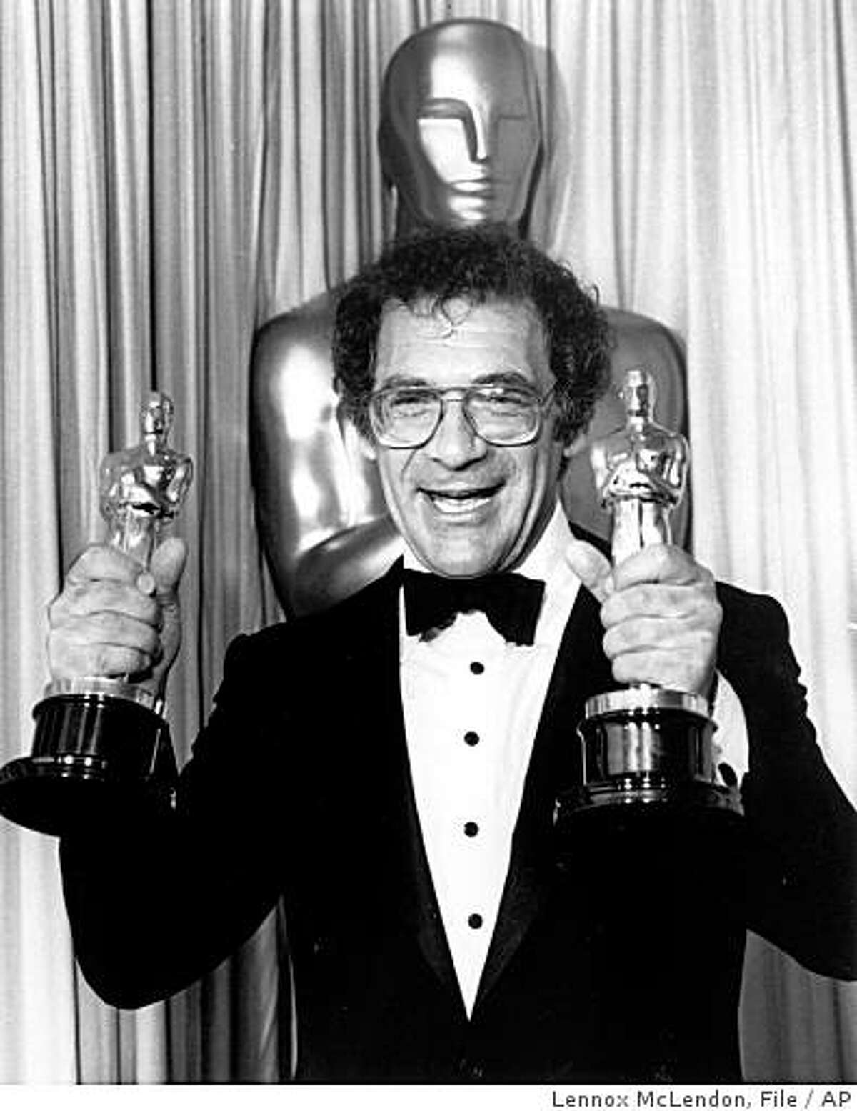 In this March 25, 1986 file photo, Sydney Pollack holds his two Oscars at the Academy Awards in Los Angeles. Pollack won best director for "Out of Africa," which he also produced and won best picture of the year.