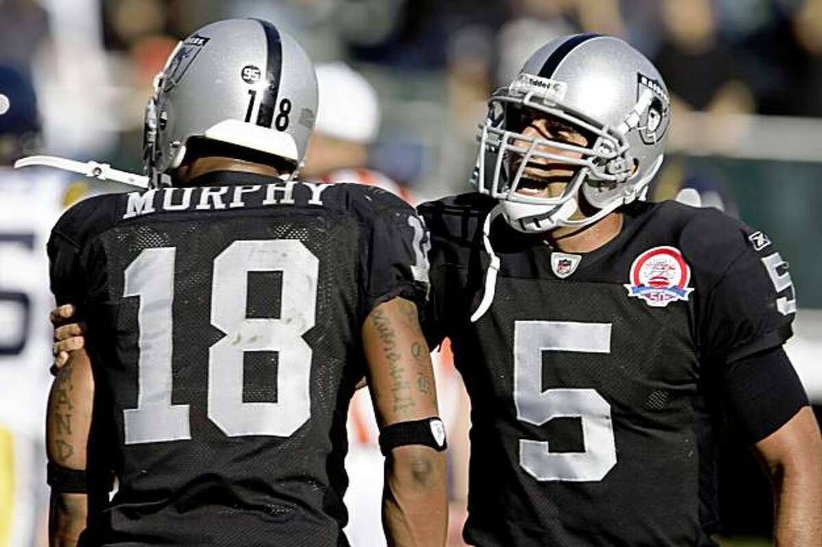 Raiders quarterback Bruce Gradkowski holds back Louis Murphy from yelling at the referee about an interference call in the end zone in the final minutes of the fourth quarter.