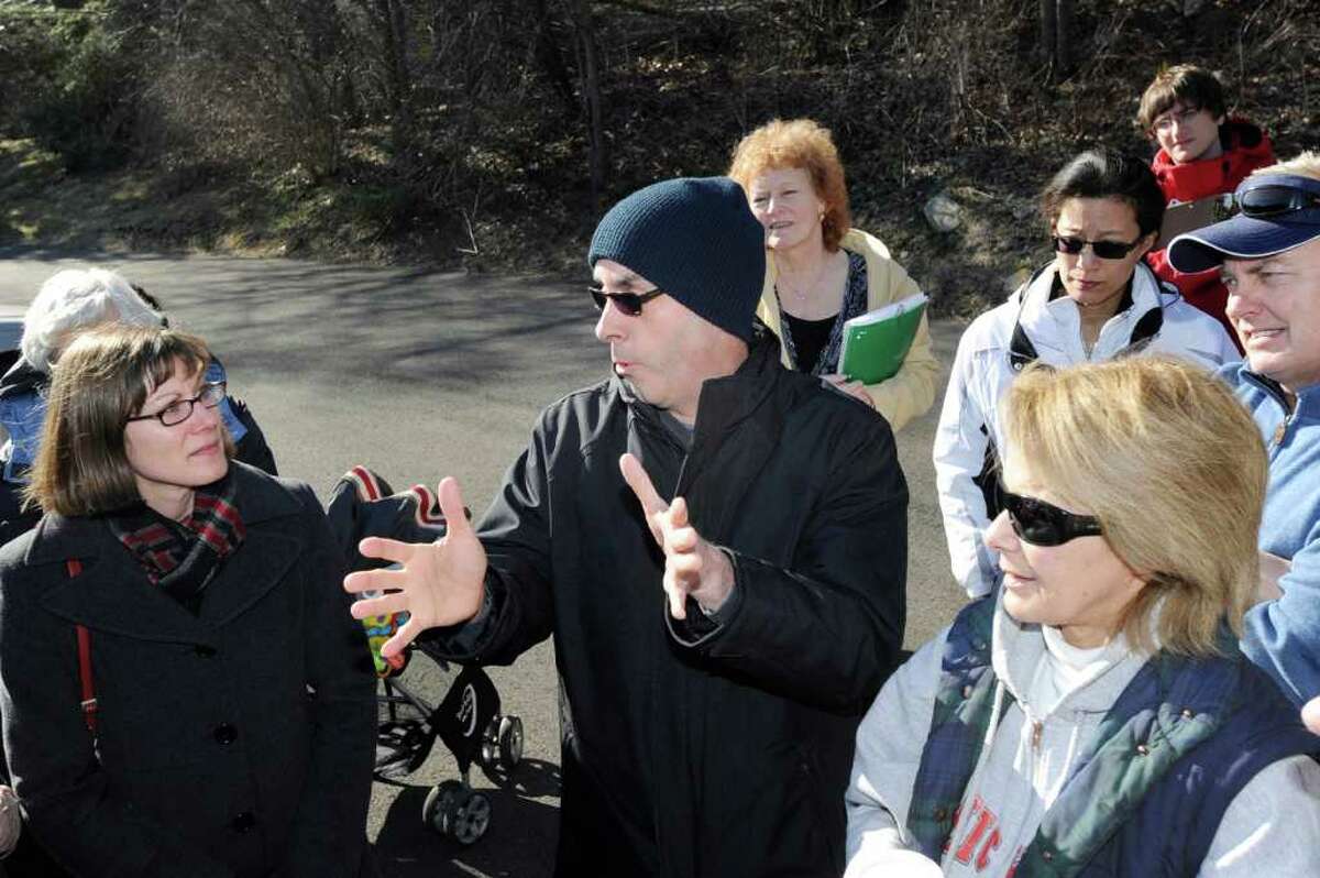 Greenwich resident, Thomas Agresta, center, makes a point to Melanie Bachman, left, staff attorney for the State of Connecticut Siting Council at the site of AT&T's proposed 17.5-foot concealed wireless tower, which would sit atop Aquarion Water Co.'s 48-foot water tower at 455 Valley Road, Cos Cob,Thursday, Feb. 9, 2012. The siting council, along with area residents, toured the proposed cell tower site Thursday. Agresta said that he lives across the Mianus River opposite the site.