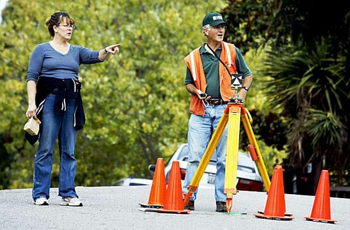 Oakland resident Pamela Koenders stops to ask US Geological survey scientists James J. Lienkaemper what he's doing. Lienkaemper and fellow scientist Jonathon Polly measure the "creep" along the Hayward Fault detecting movement within a fraction of a millimeter. 