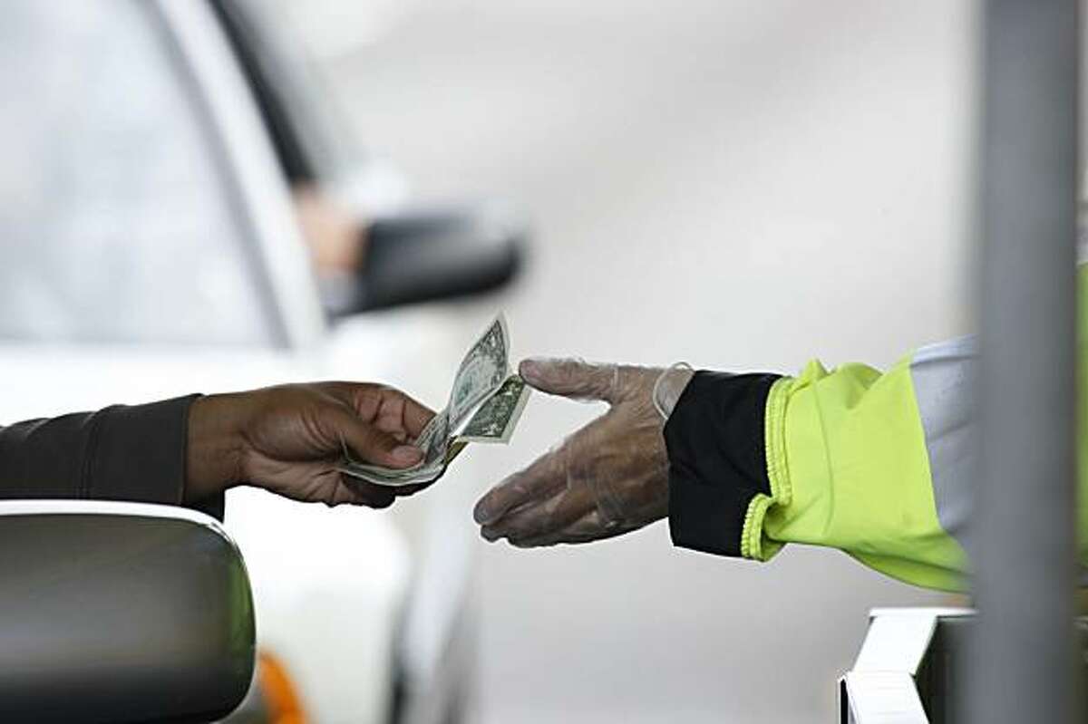 A driver pays the toll before crossing the Bay Bridge in Oakland, Calif. on Wednesday, October 14, 2009.