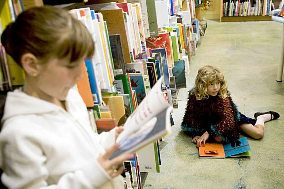Anise Fernandez (left) and a friend check out the selection of children's books during the opening night party for the new Berkeley store of Books Inc., a locally owned independent bookstore chain, in Berkeley, Calif., on Thursday, October 8, 2009.