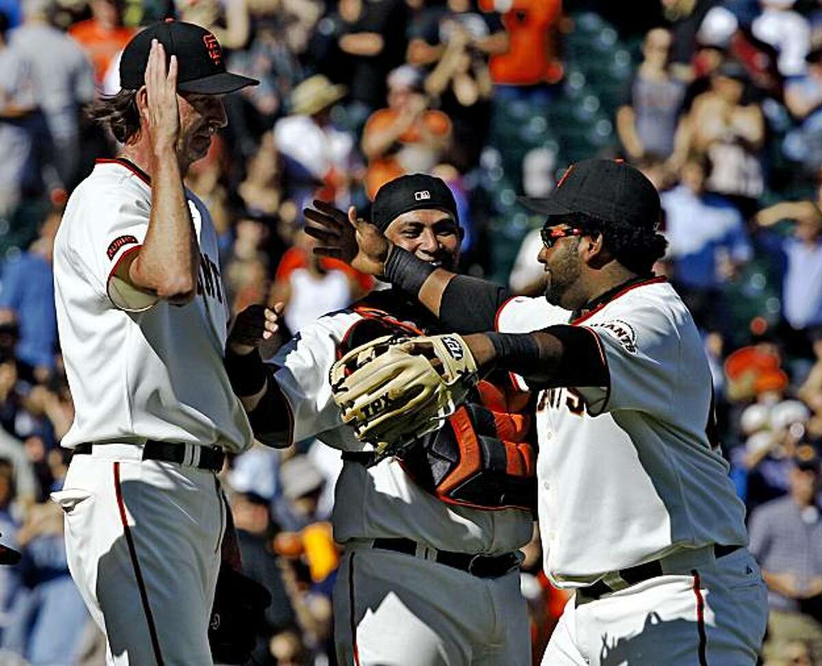 Bengie Molina and Pablo Sandoval congratulate Randy Johnson after he gets the last out against the Arizona Diamondbacks.