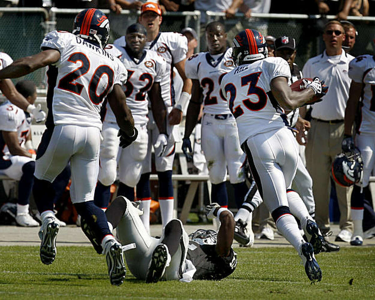 Denver safety Renaldo Hill intercepts a JaMarcus Russell pass in the first half of a Raiders-Broncos game Sunday.