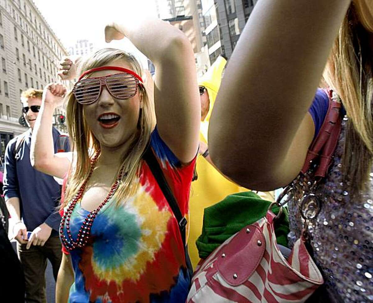 People dance and party along the parade route as LovEvolution makes its way down Market Street to Civic Center Plaza in San Francisco on Saturday.