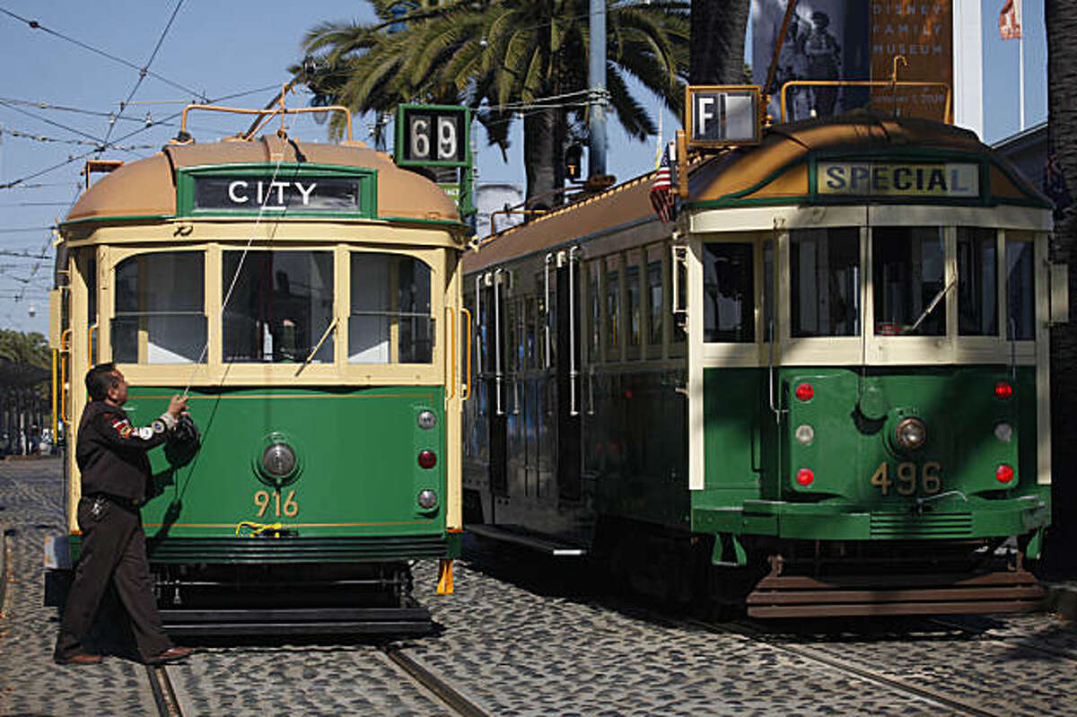 Nelson Alfaro works in front of the new Melbourne Tram No. 916 (left) that will join San Francisco's historic streetcar line.