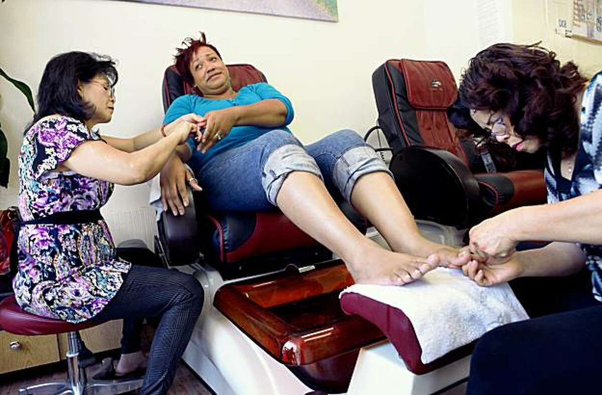 OAKLAND,CA--- Nancy Nguyen works on Michelle Robinson's fingernails and her sister, Kim Nguyen works on her toenails at Lisa's Nails on Grand Avenue on Monday, Oct. 5, 2009. Robinson has a hair salon in Oakland called "Naturally Your's" and comes to Kim's Nails because of the price and quality of the manicures and pedicures. There has been a proliferation of nail salons in Oakland and the City Council is considering trying to limit any more nail salons from opening.