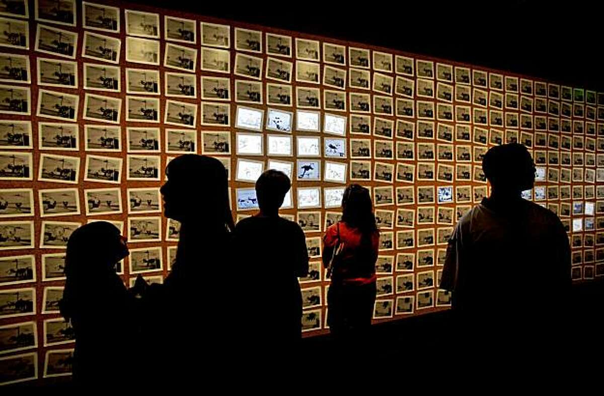 Visitors explore the 348 frames used to create the animated cartoon, "Steamboat Willie", during the grand opening of the Disney Family Museum on Thursday October 1, 2009 in San Francisco, Calif.