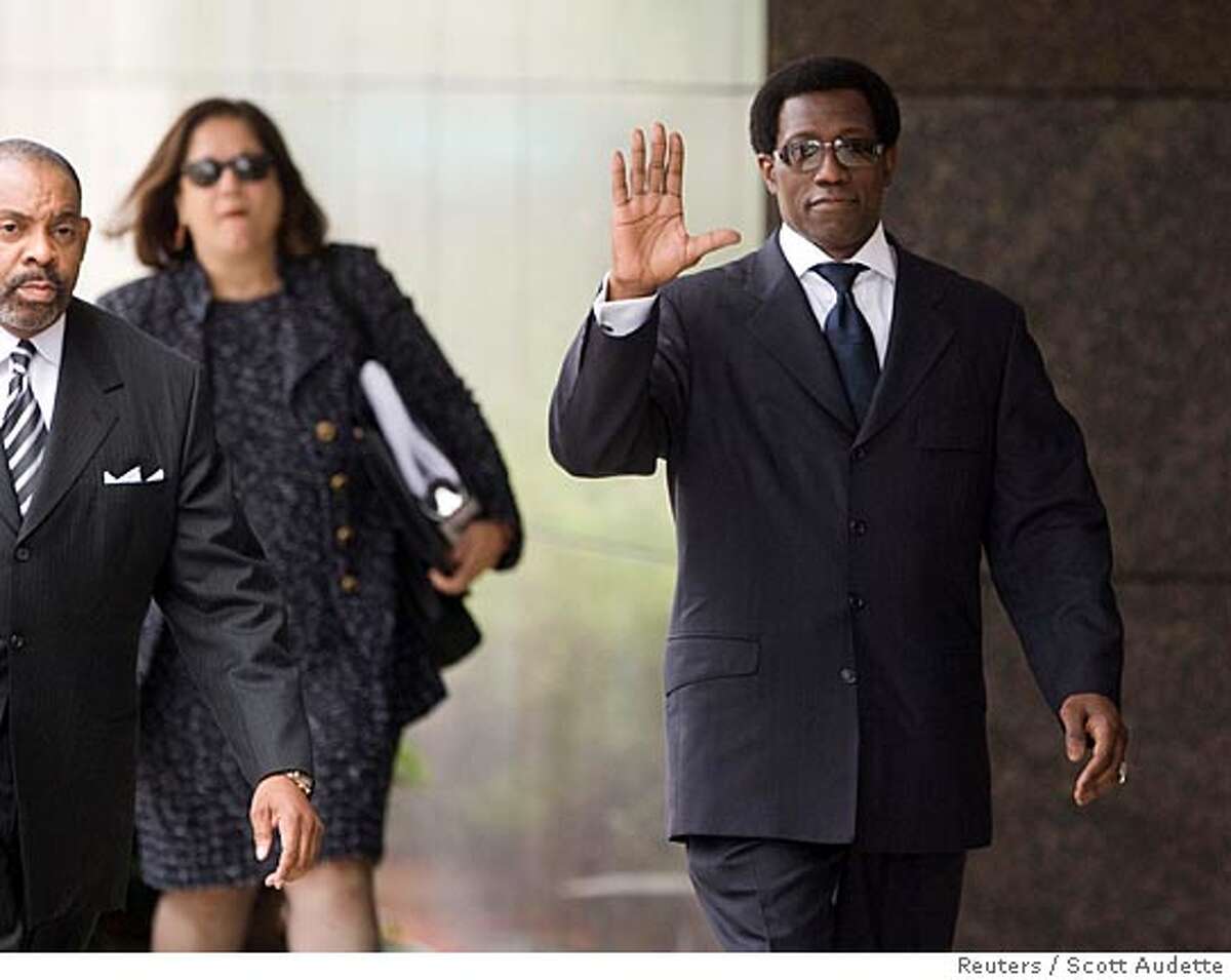 Actor Wesley Snipes (R) waves while walking into the federal courthouse for sentencing in Ocala, Florida April 24, 2008. Snipes, who starred in the "Blade" movies series, was convicted in February on three misdemeanor counts of willfully failing to file federal tax returns for 1999-2001. REUTERS/Scott Audette (UNITED STATES)