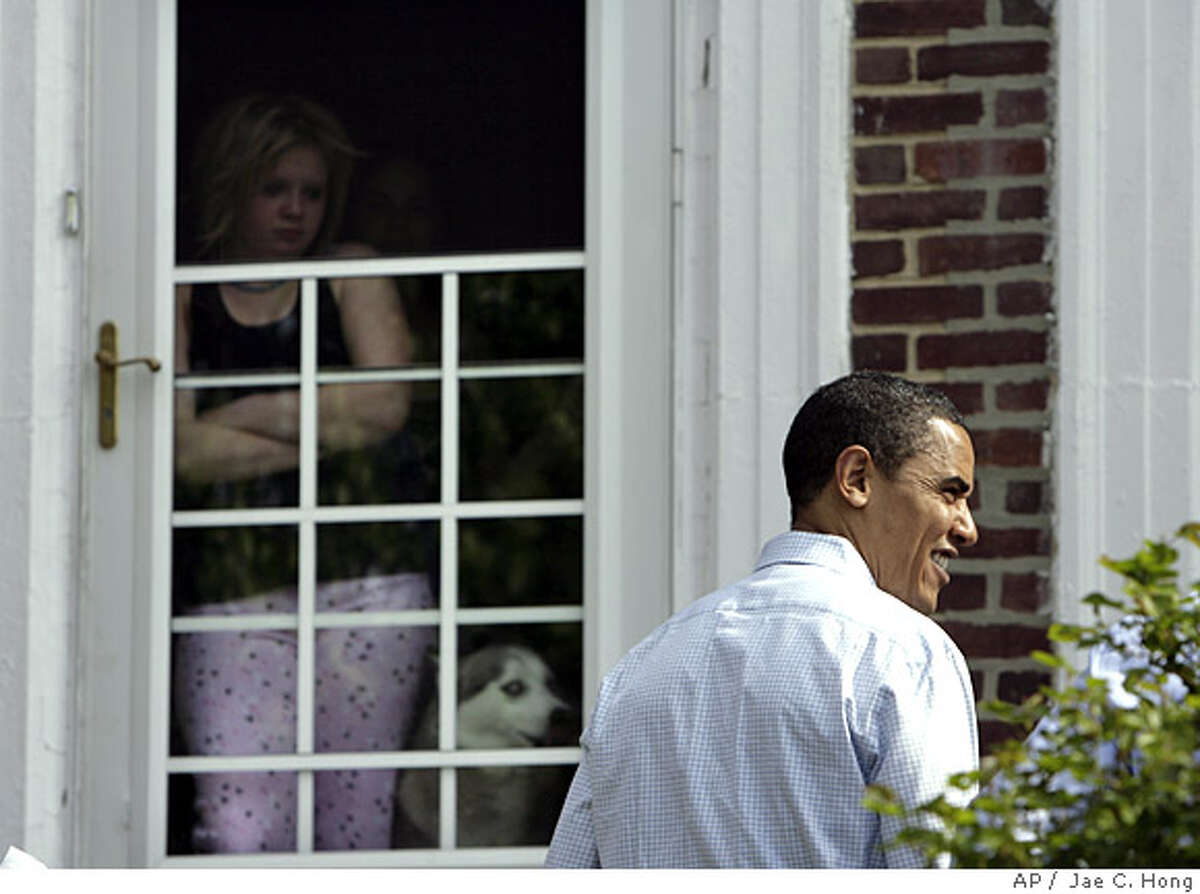 A woman watches as Democratic presidential hopeful, Sen. Barack Obama, D-Ill., right, campaigns door to door in Philadelphia, Saturday, April 19, 2008. (AP Photo/Jae C. Hong)