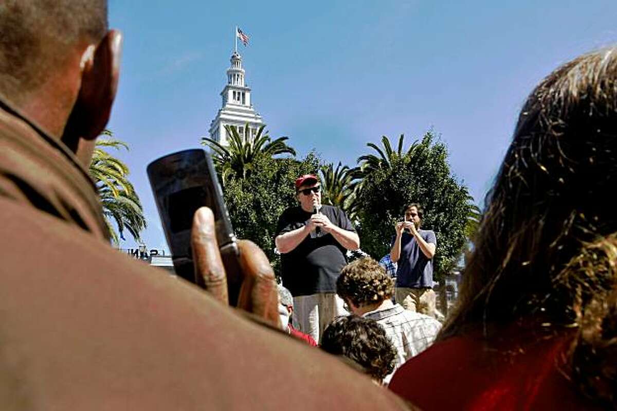 Members of the crowd record and photograph Michael Moore with their cellphones as he speaks about his new movie "Capitalism: A Love Story" in Justin Herman Plaza, Thursday Sept. 17, 2009, in San Francisco, Calif.