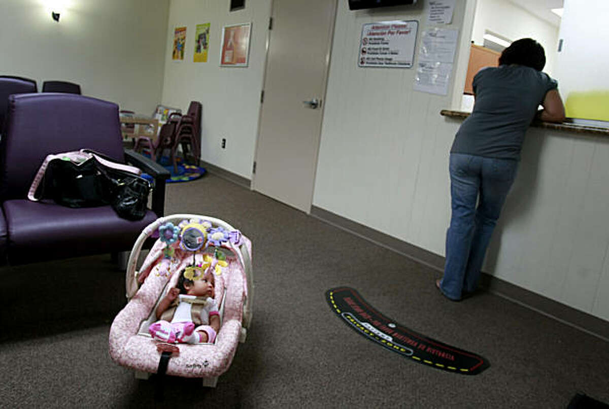 A new mother checks in at the clinic as her daughter waits.
