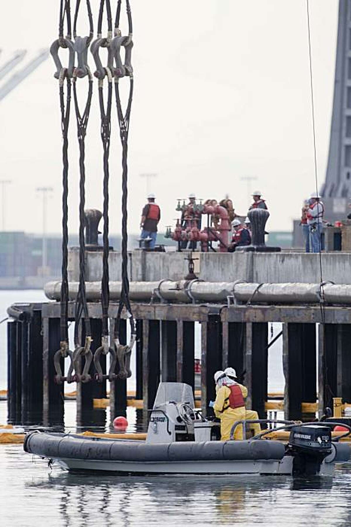A recovery crew works to lower cables used to salvage the sunken U.S.S Wenonah.