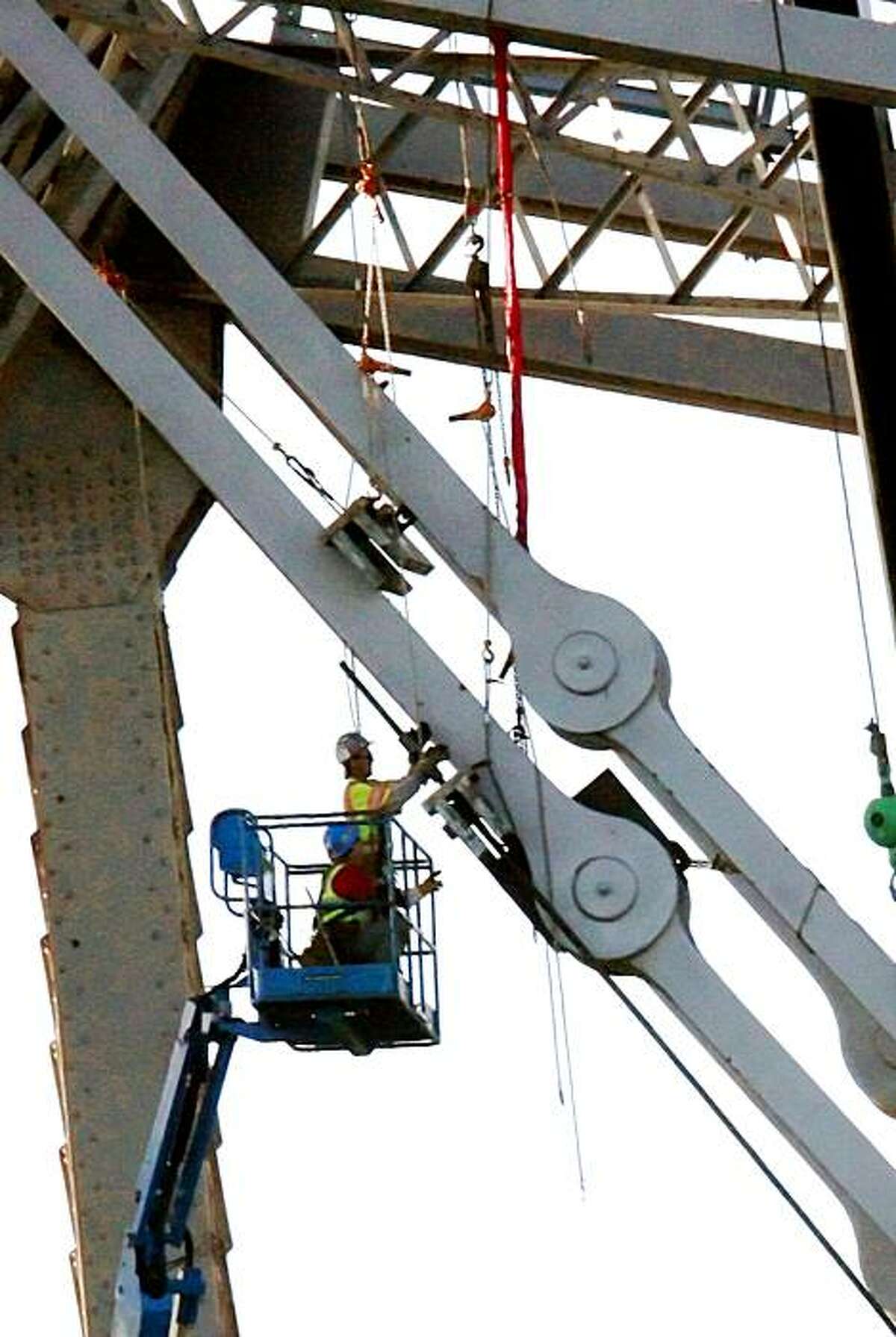 Workers work on the eastern tower of the Bay Bridge reinforcing a cracked eyebar on September 7, 2009 in Treasure Island, Calif.