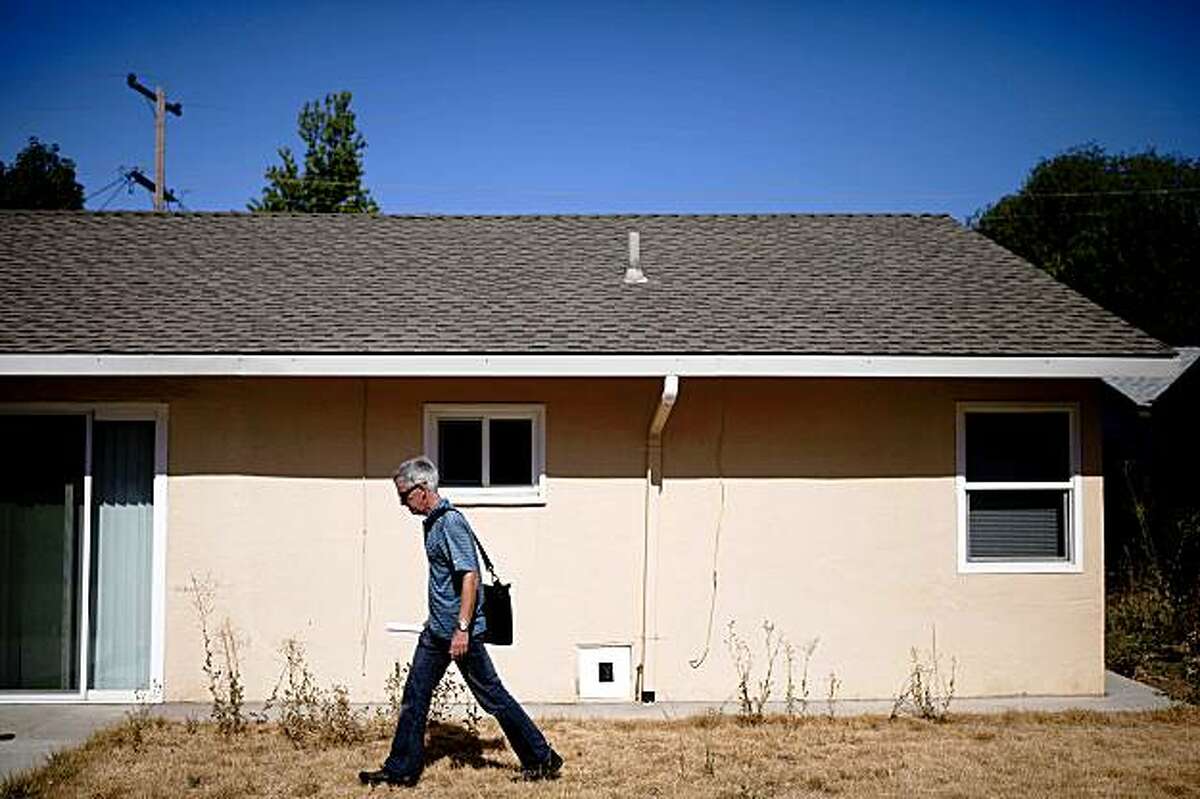 Working with Oakland's McKinley Partners, Paul Staley, vice president of Staley and MacArthur Inc Real Estate Services, surveys the backyard of a bank-owned house they're considering investing in Pittsburg, Calif. on Monday, July 27, 2009. McKinley has formed a $6 million fund to purchase foreclosed homes in eastern Contra Costa towns, forecasting their potentials to double its value in five years.