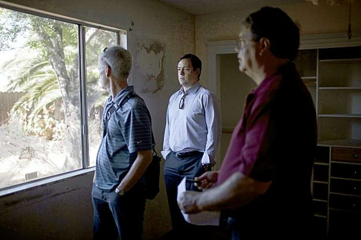 From left, Paul Staley, vice president of Staley and MacArthur Inc Real Estate Services, Gregor Watson, managing partner of Oakland's McKinley Partners, and Ron McArthur, vice-president of Staley and MacArthur looks at the backyard of a bank-owned house they're considering investing in Pittsburg, Calif. on Monday, July 27, 2009. McKinley has formed a $6 million fund to purchase foreclosed homes in eastern Contra Costa towns forecasting their potentials to double its value in five years.