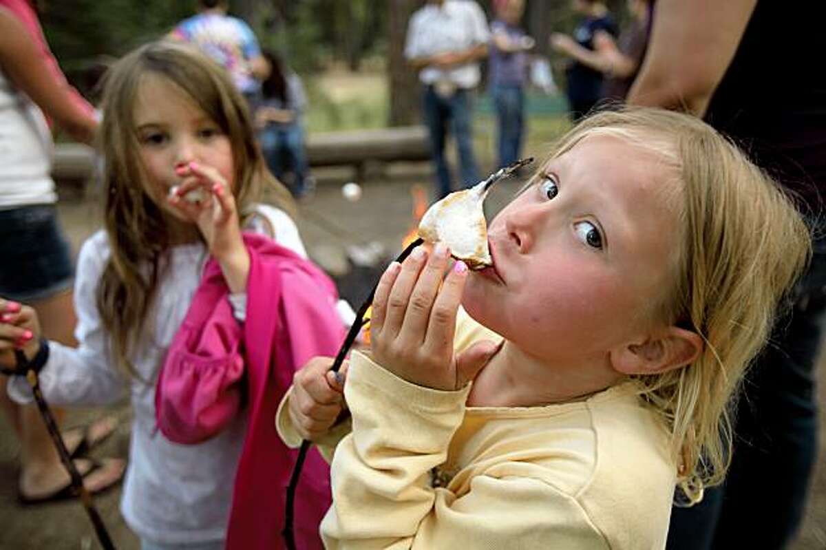 Sophia Compton and Grace Sandbatch enjoy roasted marshmallows during a hayride excursion at Camp Mather on Wednesday, July 30, 2009. Mather Saddle and Pack Station owner, Jay Barnes says he's seen a downturn in ride participants because of the economic slump. Camp Mather, which until now has always been booked solid and is the coveted summer prize for families year after year, has seen a dip in attendance from a downturn in the economy. Mather is a San Francisco institution. It is a tradition for many, many families and is one of the few affordable getaways for city kids and middle class families.