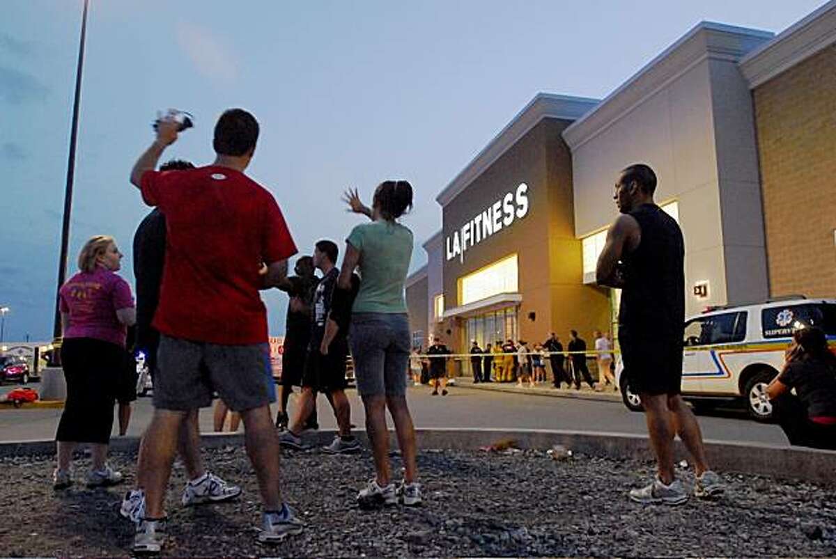 Patrons stand in the parking lot outside of LA Fitness in Bridgeville Pa. after a reported shooting at the health club on Tuesday, Aug. 4, 2009. (Joe Appel/Tribune-Review) ** MANDATORY CREDIT, PITTSBURGH OUT, HERALD-STANDARD OUT **
