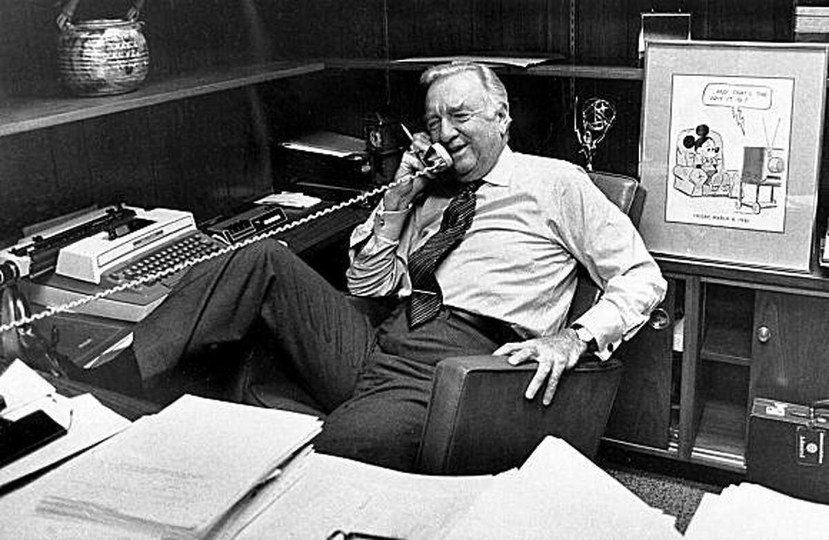 In this March 6, 1981 file photo, Walter Cronkite talks on the phone at his office, prior to his final newscast as CBS anchorman in New York City. Behind him is a framed Mickey Mouse cartoon and his Emmy award. Famed CBS News anchor Walter Cronkite, known as the 'most trusted man in America' has died, Friday, July 17, 2009. He was 92.