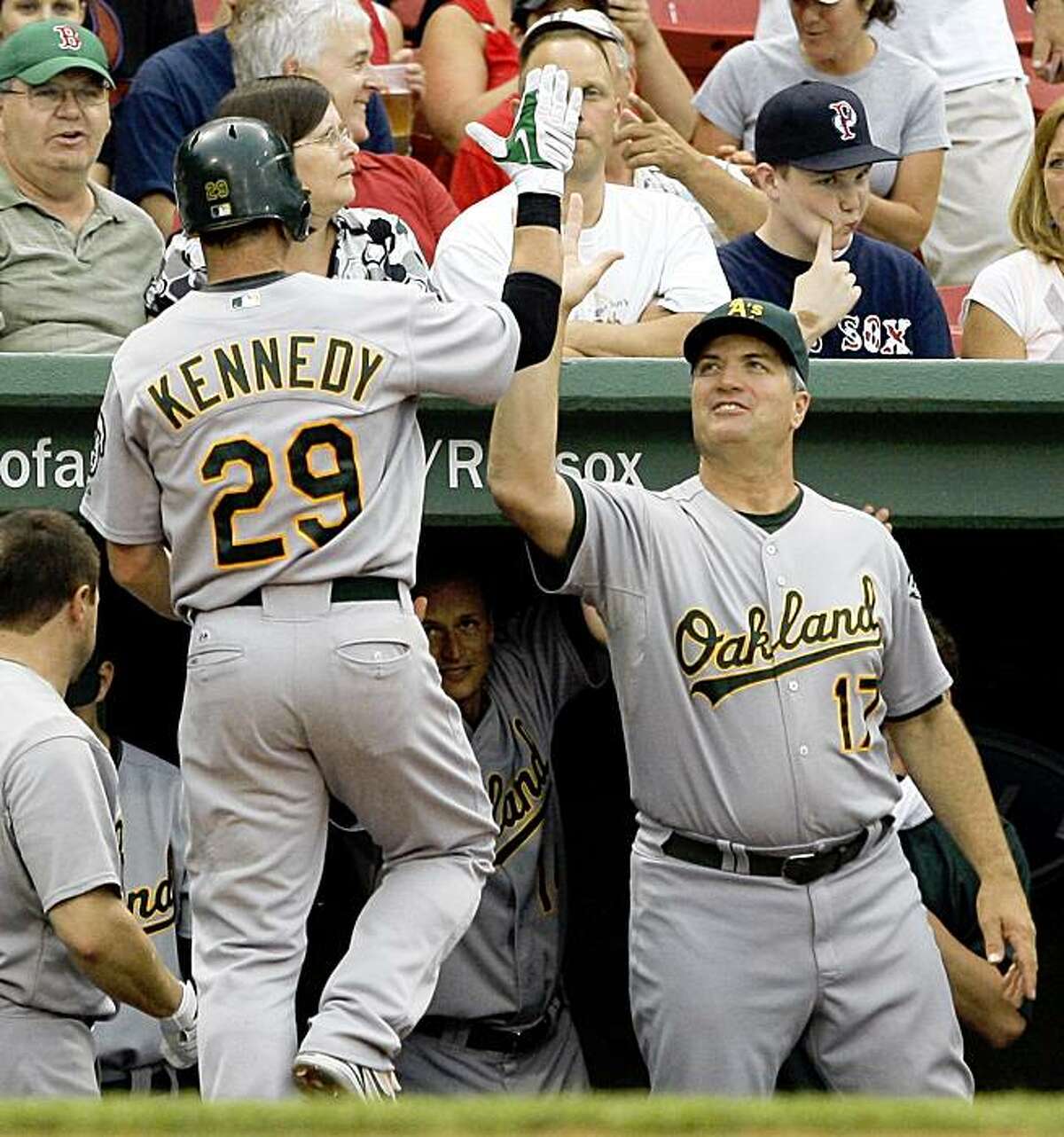 Oakland Athletics' Adam Kennedy (29) receives a high-five from manager Bob Geren, right, after hitting a solo home run against the Boston Red Sox in the first inning of a baseball game at Fenway Park in Boston, Wednesday, July 29, 2009.