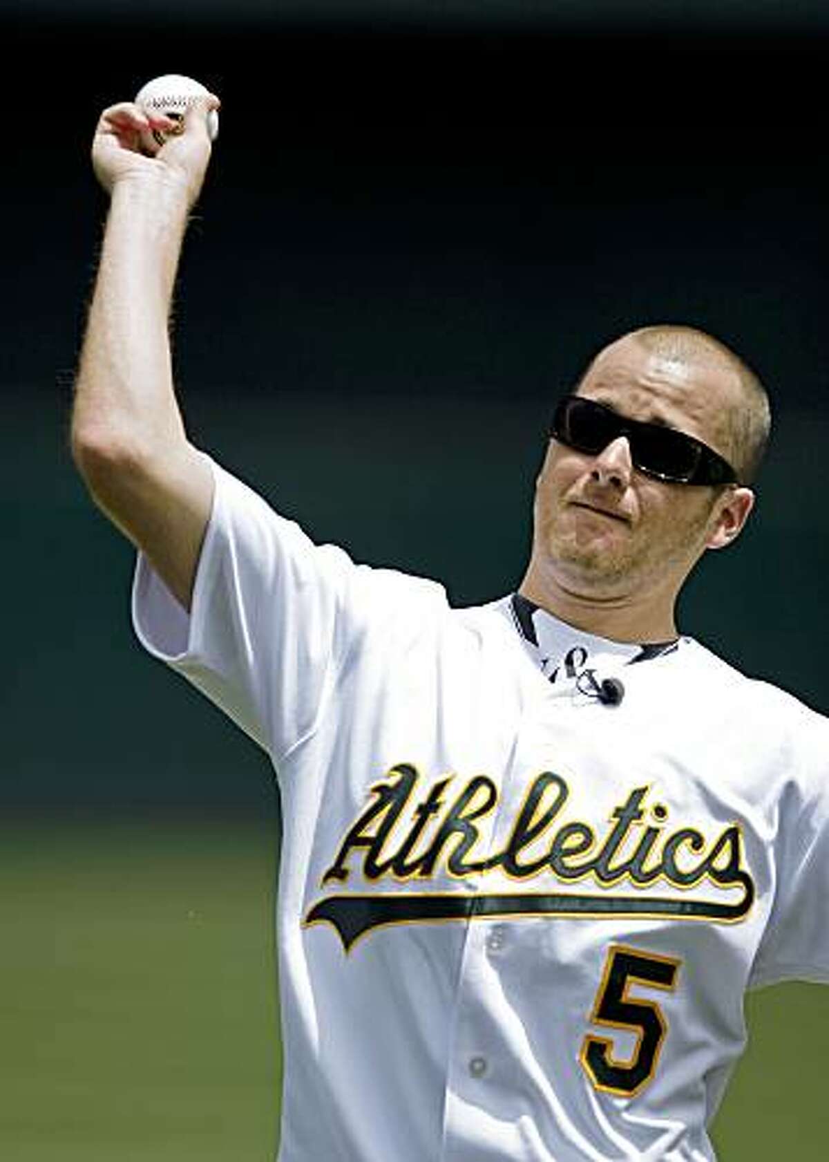 Jon Wilhite, former Cal State Fullerton baseball star, throws the ceremonial first pitch to his former teammate, Oakland Athletics catcher Kurt Suzuki, not shown, before a baseball game between the A's and the Los Angeles Angels, Saturday, July 18, 2009, in Oakland, Calif. Wilhite is the sole survivor of the April 9 car crash that killed Angels pitcher Nick Adenhart, Henry Pearson and Courtney Stewart. (AP Photo/Ben Margot)