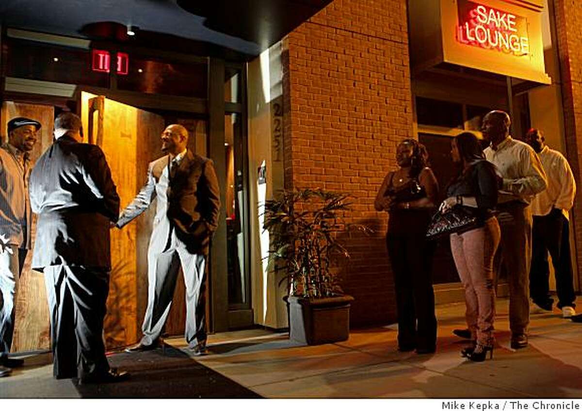 "This was a ghost town a year ago," said Merlin Edwards (2nd man from left) as he limits entry to a crowd of people trying to get into Ozumo, a new upscale sushi bar and lounge in the Broadway Grand complex on Friday June 5, 2009 in Oakland, Calif.