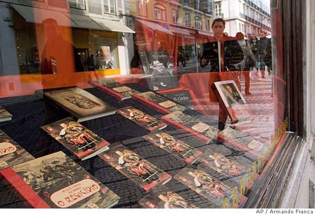 **APN ADVANCE FOR SUNDAY FEB. 17** People walk by a bookstore window decorated with books about Portugal's last King, Carlos I, and his assassination, Friday, Jan. 25 2008, in downtown Lisbon. February 1st marks the 100th anniversary of the assassination of the 44-year-old king and his eldest son Prince Luis Filipe. (AP Photo/Armando Franca) **APN ADVANCE FOR SUNDAY FEB. 17**