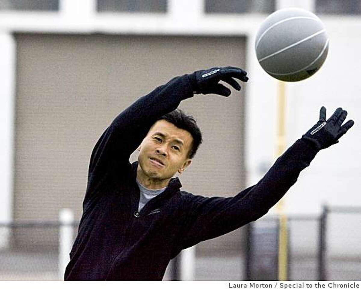 Paul Chan works on throwing a weighted ball during a fitness class organized by BootCampSF outside at China Basin in San Francisco, Calif., on Friday, June 12, 2009.