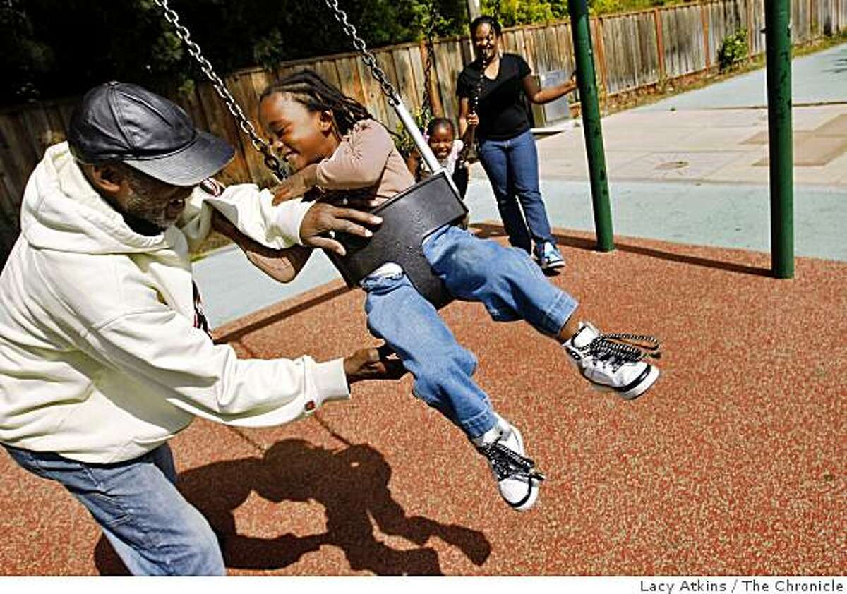 Joe Williams plays with his grandaughter Ebony Williams, 4years old, as Imani Clifton and mother Dana Thomas swing at the Hollis Park, Monday June 8, 2009, in Emeryville, Calif.