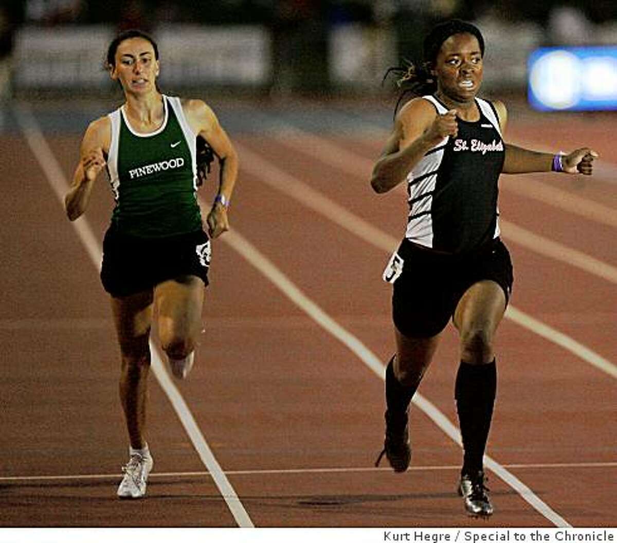 Ashton Purvis of Saint Elizabeth , right, passes Angela Gradiska of Pinewood to win the 200 meter race during the finals of the California State Track and Field Championships in Clovis, Ca Saturday May 6,2009.