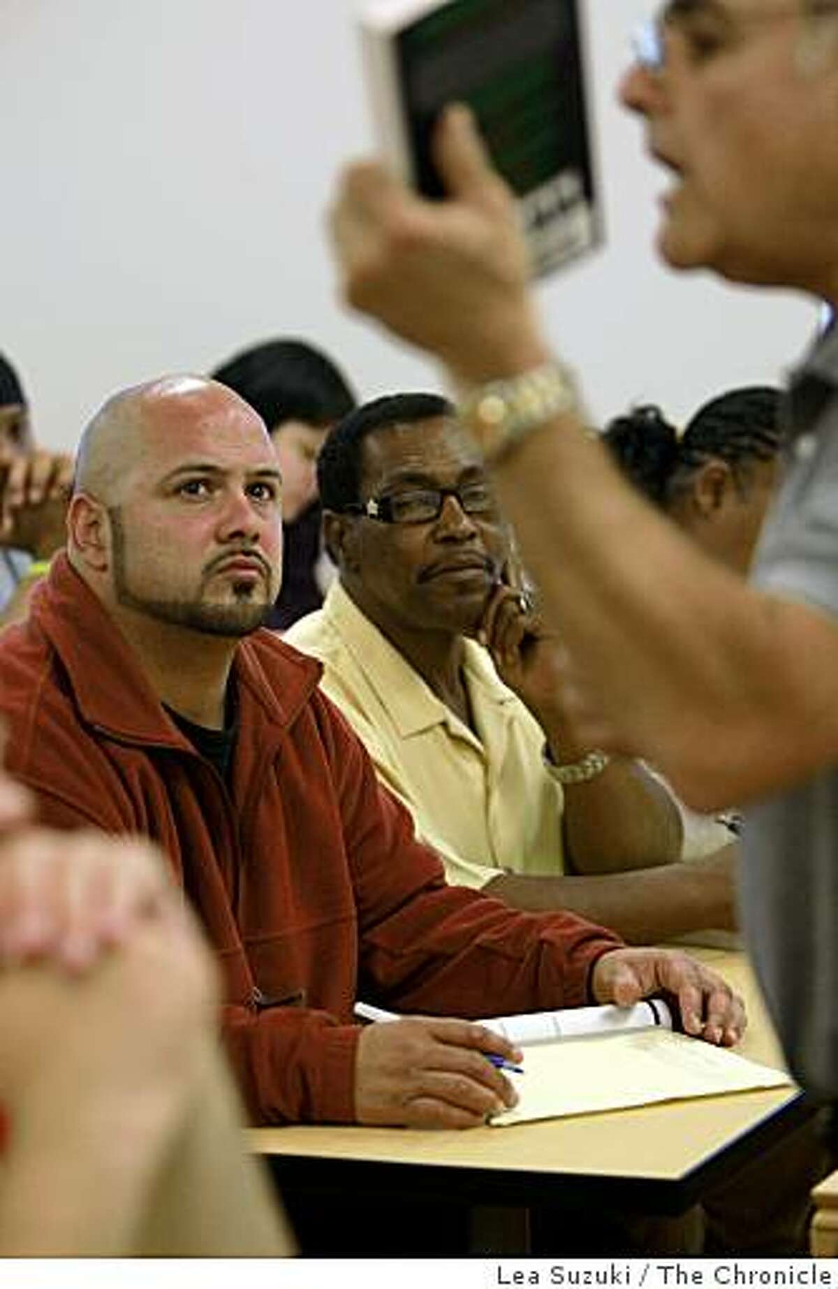 Alex Humphrey (in red jacket) and Eli Crawford (in yellow shirt) listen to Professor Frederick Chavaria, Department Chair Administration of Justice and Fire Science Technology, lecture during class at the City College Mission Campus in San Francisco, Calif. on Tuesday, June 16, 2009.
