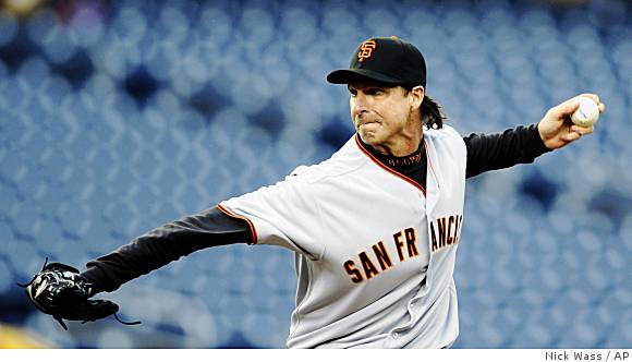 San Francisco Giants pitcher Randy Johnson tips his hat to the crowd with  his son Tanner after he won his 300th victory against the Washington  Nationals in Washington on June 4, 2009.