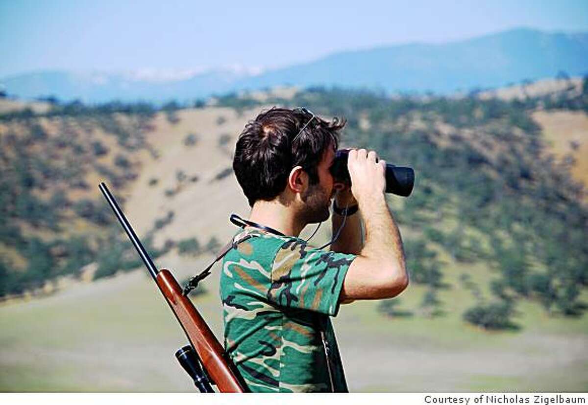 Nick Zigelbaum uses binoculars to hunt for game.