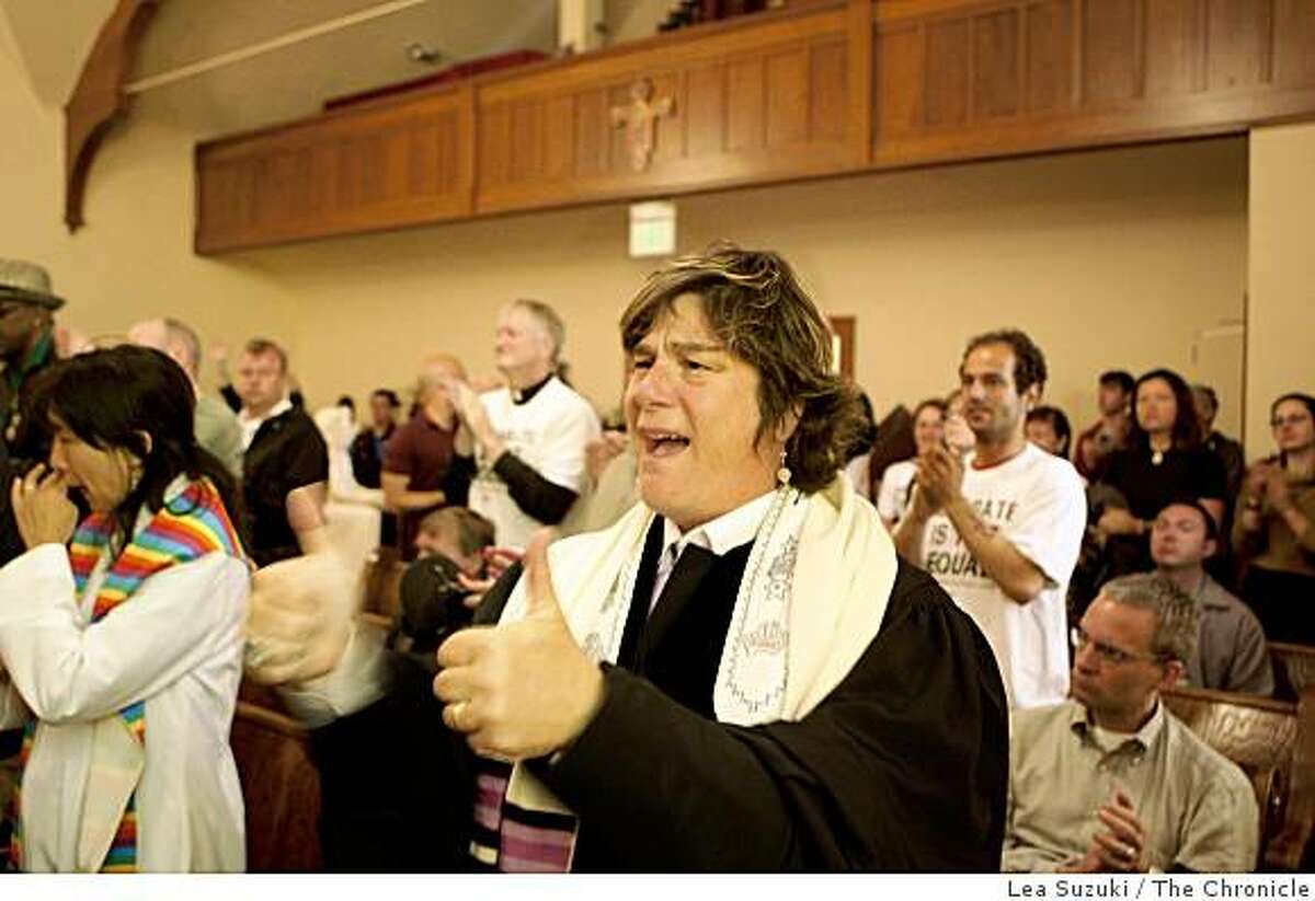 Rabbi Camille Shira Angel of Congregation Sha-ar Zahav cheers with others during service at St. Francis Lutheran Church in San Francisco on Tuesday.