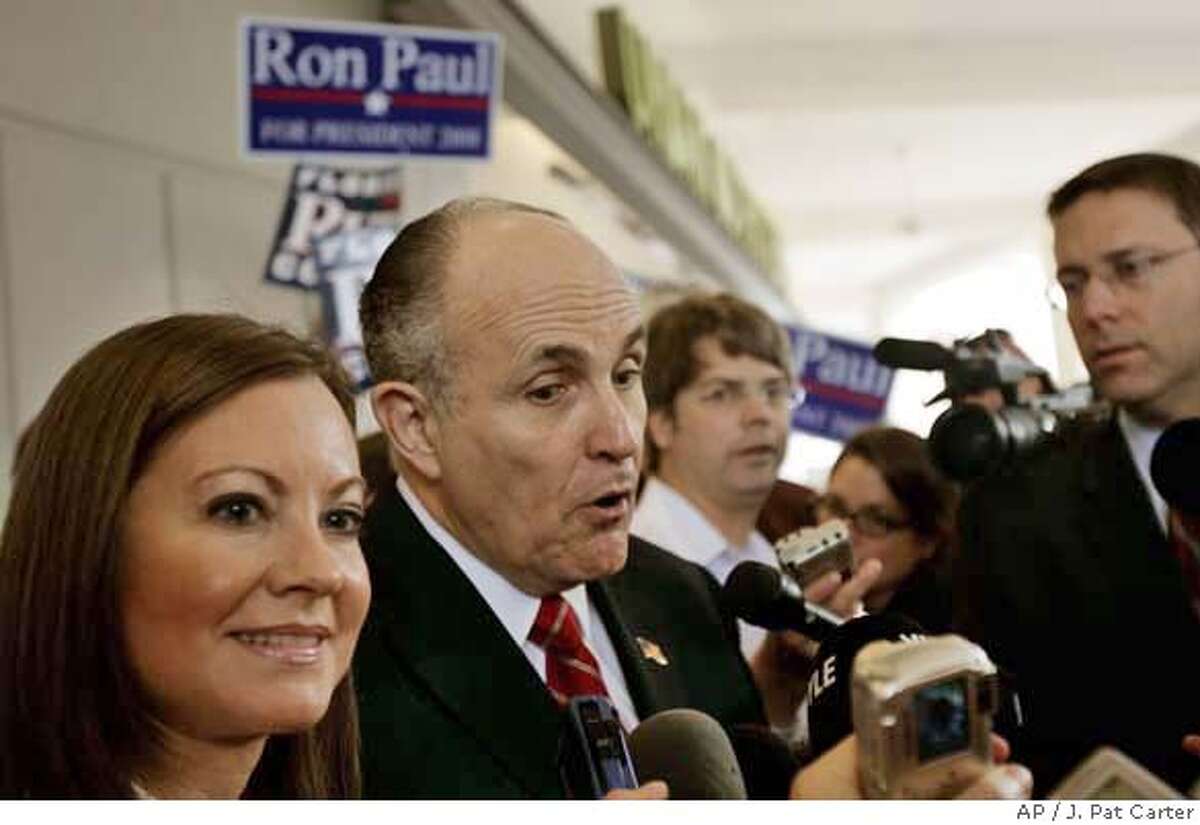 With Ron Paul supporters behind him, Republican presidential hopeful, former New York City Mayor Rudy Giuliani, accompanied his wife Judith, talks to the media and supporters at campaign rally in Palm Beach Gardens, Fla., Tuesday, Jan. 22, 2008. (AP Photo/J. Pat Carter)