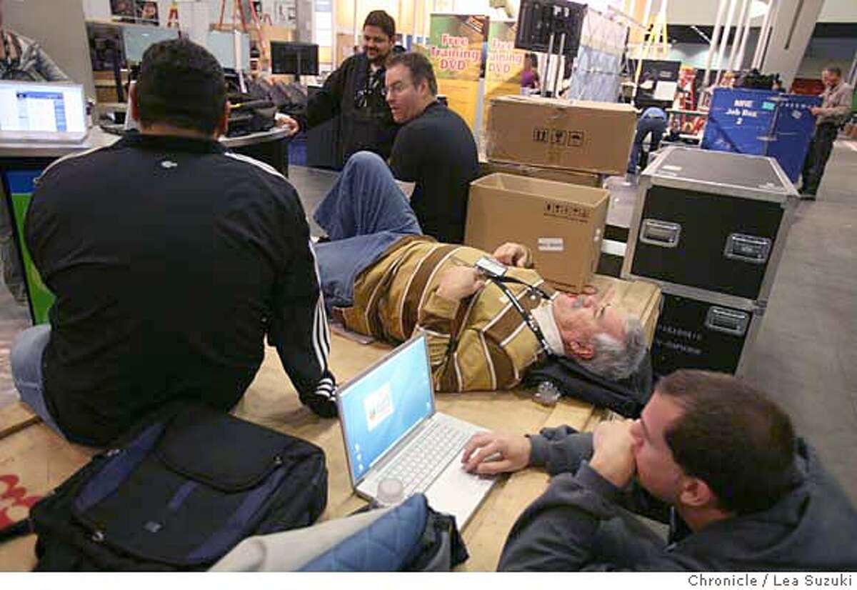 Monte Neece, field marketing manager with Creative Labs, (center lying down) lays down on some boxes while working at the Creative Labs exhibit at the Macworld Conference & Expo which opened on Monday January 14, 2008 in San Francisco, CA. On Tuesday the Expo opens. Neece had hurt his back at CES (Consumer Electronic Show) in Las Vegas held from Jan 7-10 so was resting it. Lea Suzuki/ The Chronicle