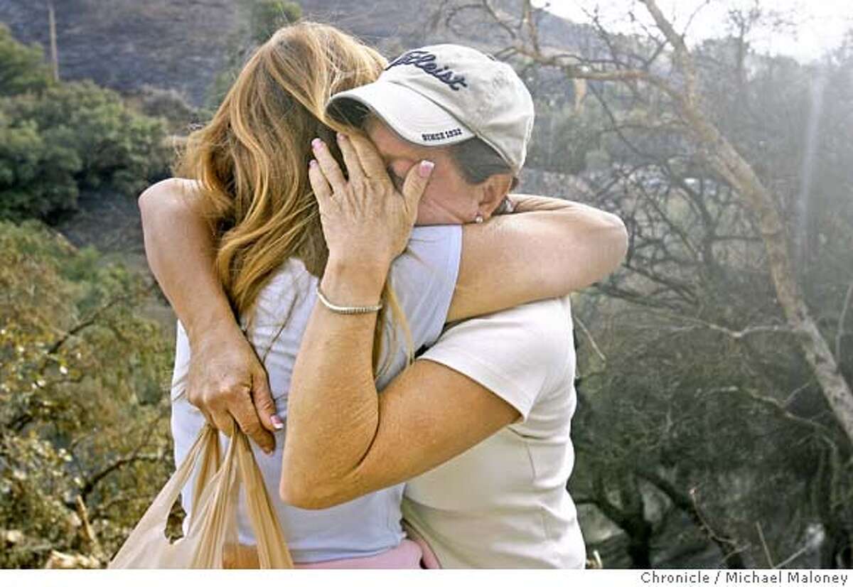 Priscilla Avedon (with hat) gets a hug from her neighbor and friend Cynthia Benjamin after seeing her Corral Canyon home destroyed by the Saturday morning fire. She had just moved into the home less than 2 weeks ago. A fast-moving wildfire pushed by Santa Ana winds destroyed nearly 50 homes and forced thousands of residents to evacuate on Saturday as flames raced through the canyons and mountains of Malibu for the second time in little more than a month. On Sunday, favorable weather conditions overnight helped decrease the danger however a mandatory evacuation was still in place in the fire zone. Photo taken on 11/25/07, in Malibu, CA. Photo by Michael Maloney / San Francisco Chronicle ***Priscilla Avedon, Cynthia Benjamin