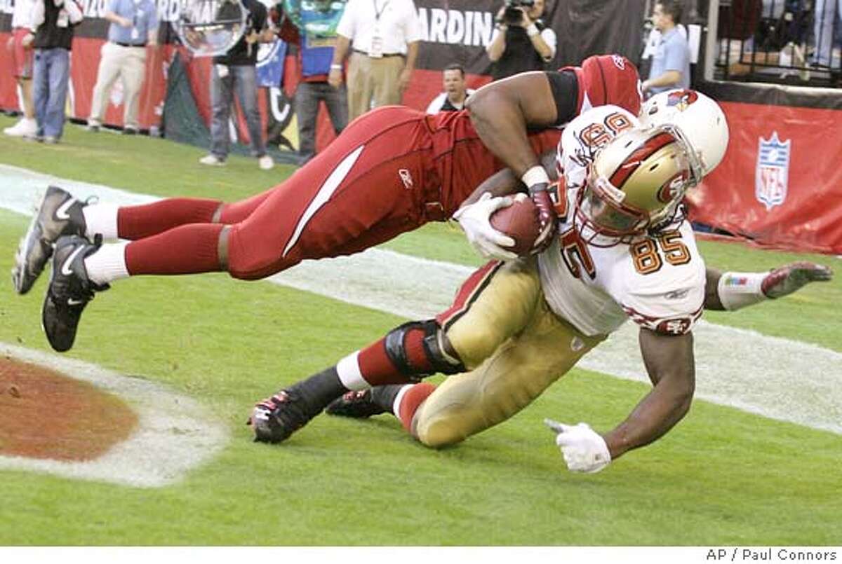 San Francisco 49ers' Vernon Davis (85) hauls in a touchdown catch as Arizona Cardinals' Karlos Dansby, back, comes in late in the first quarter of an NFL football game Sunday, Nov. 25, 2007, in Glendale, Ariz. (AP Photo/Paul Connors)