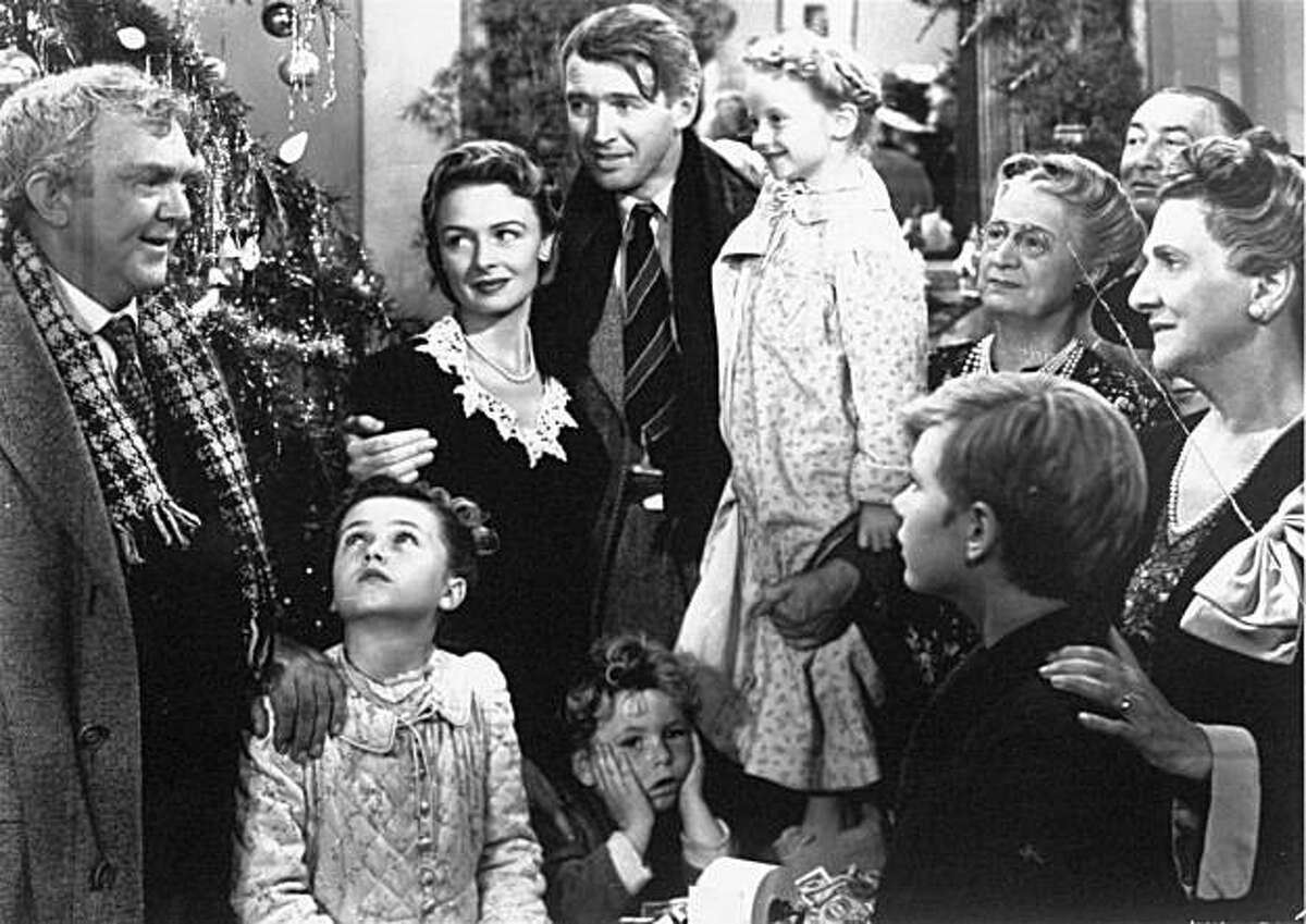 James Stewart, center, as George Bailey is reunited with his wife, played by Donna Reed, left center, and their children during the final scene of Frank Capra's 1946 movie, "It's A Wonderful Life."