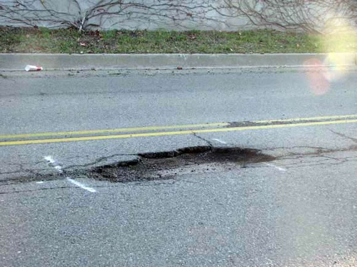 A file photo of a pothole on Aliso Avenue in Oakland.  The city of Oakland paid out a $3.25 million settlement to a woman who was severely injured after she hit a pothole and crashed on her bike.