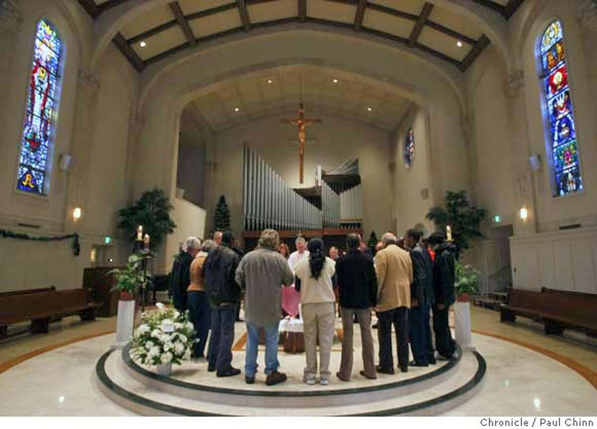 Mourners gather around the altar during a memorial service for John Johnson at Our Lady of Lourdes Church in Oakland, Calif. on Tuesday, Dec. 18, 2007. Johnson, a 47-year-old homeless man who was a fixture in the Grand Lake neighborhood, died Sunday, Dec. 9, from an apparent heart attack. About two dozen residents and merchants attended the service which was organized by longtime area neighbor Nancy Rieser. PAUL CHINN/The Chronicle **John Johnson, Nancy Rieser MANDATORY CREDIT FOR PHOTOGRAPHER AND S.F. CHRONICLE/NO SALES - MAGS OUT