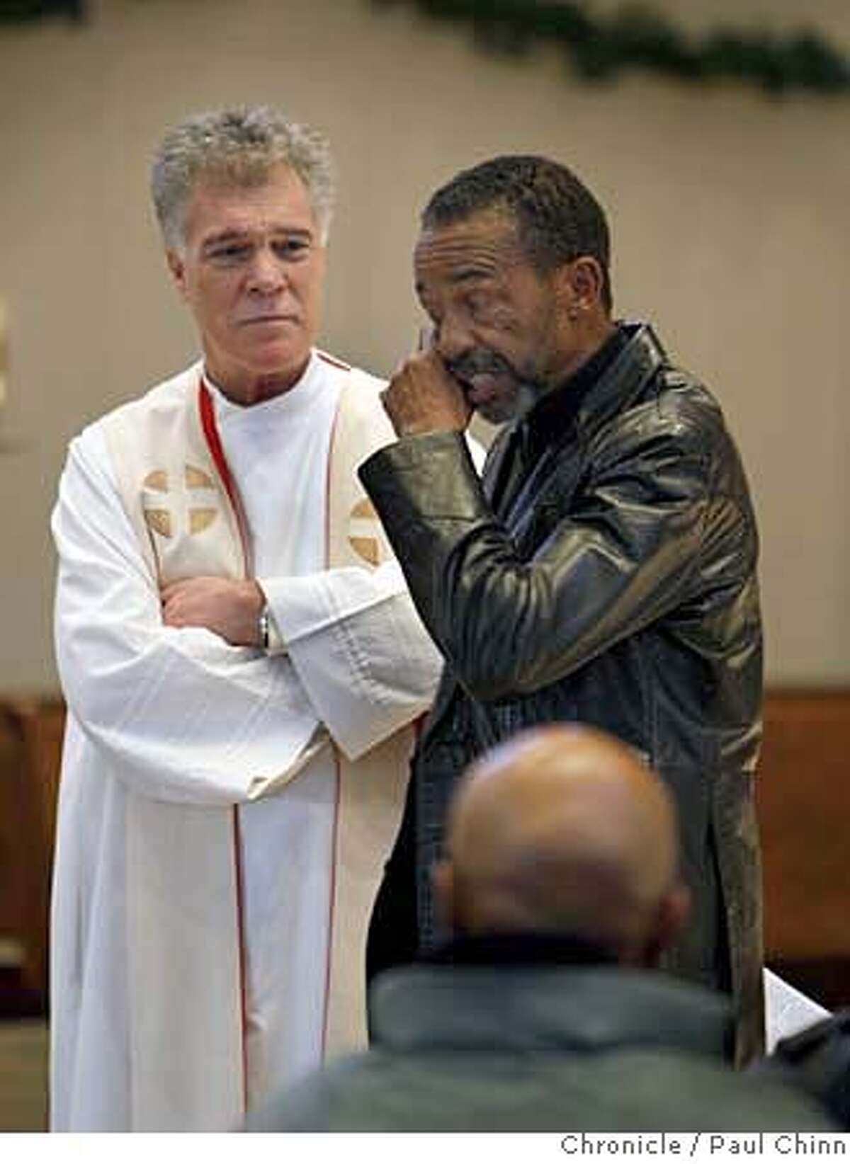 Father Seamus Genovese listens to Alphonzo Jackson tell a story about John Johnson during a memorial service for Johnson at Our Lady of Lourdes Church in Oakland, Calif. on Tuesday, Dec. 18, 2007. Johnson, a 47-year-old homeless man who was a fixture in the Grand Lake neighborhood, died Sunday, Dec. 9, from an apparent heart attack. About two dozen residents and merchants attended the service which was organized by longtime area neighbor Nancy Rieser. PAUL CHINN/The Chronicle **Seamus Genovese, Alphonzo Jackson, John Johnson, Nancy Rieser MANDATORY CREDIT FOR PHOTOGRAPHER AND S.F. CHRONICLE/NO SALES - MAGS OUT
