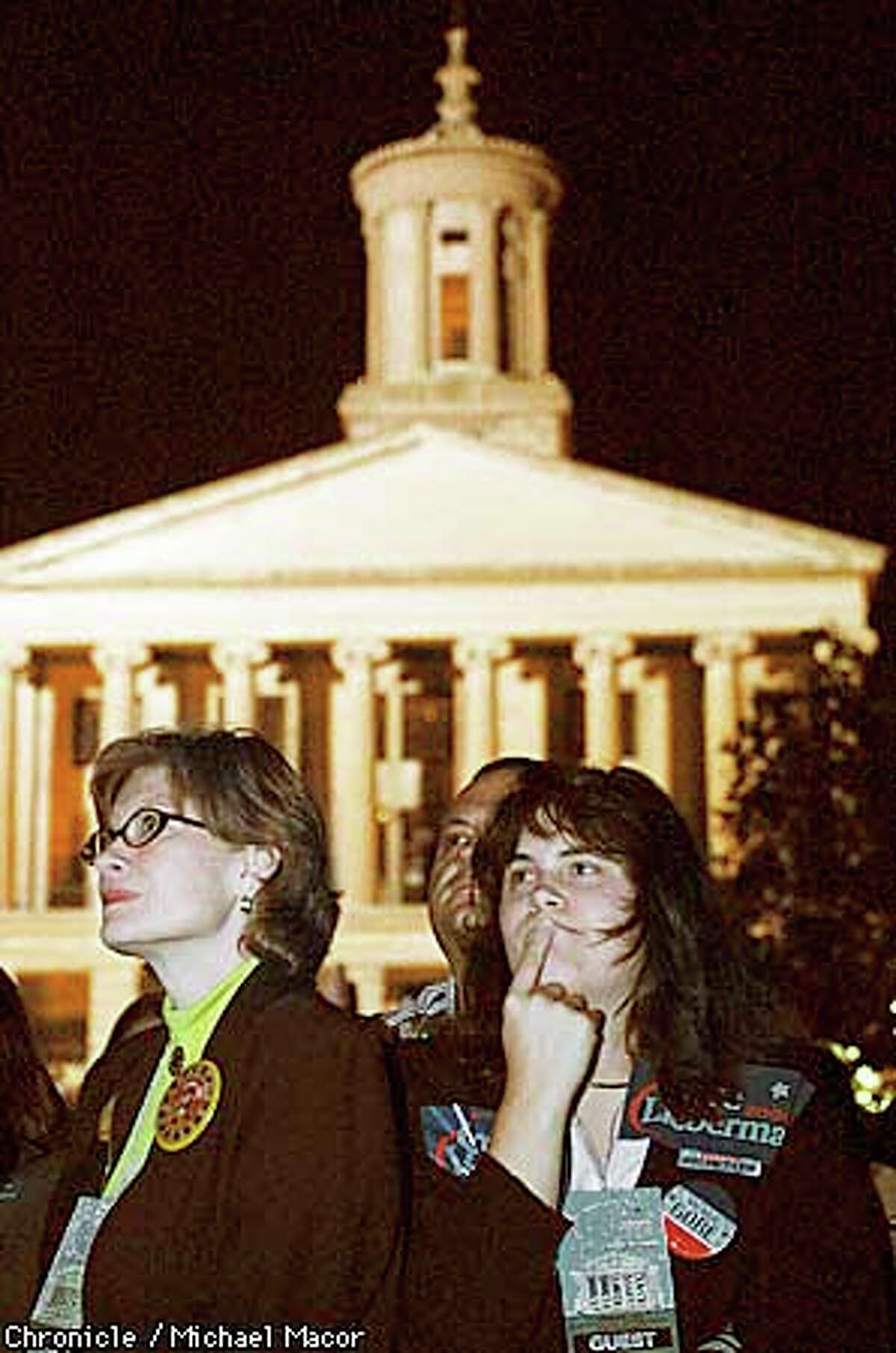 GORENIGHT1-C-07NOV00-MN-MAC Al Gore Election night headquarters in Nashville Tennessee. the Tennesse Stae Capitol building in the background of Gore supporters Barbara Quinn, Terry Rainey and Samantha Rainey. The three watch election returns on big screen TV's at the War Memorial Building. by Michael Macor/The Chronicle