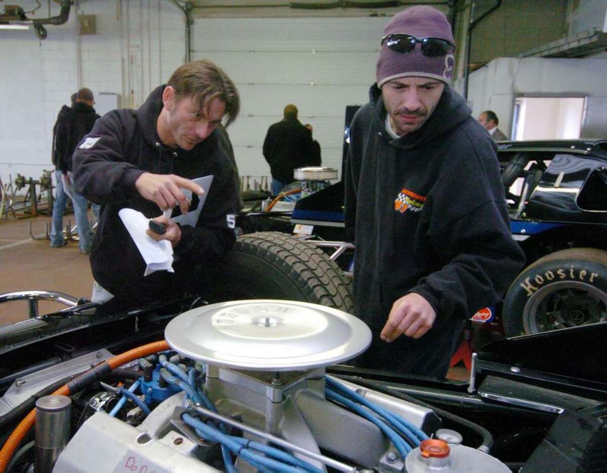From left, Gary Knight, of Charlestown, NH and Warren Mordenti, of Newport, NH, look over cars prior to an auction of seized property of James Galante's at Metro Auto Body & Towing in Harford, CT, Friday, Nov. 6, 2009. The property consisted of racing cars and parts.