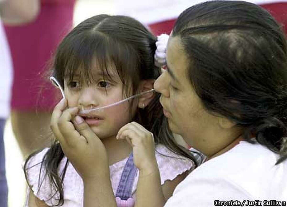 Angelas Gomez tended to her daughter, Sandy Flores, who was treated for smoke inhalation in a Mountain View fire. Chronicle Photo by Justin Sullivan