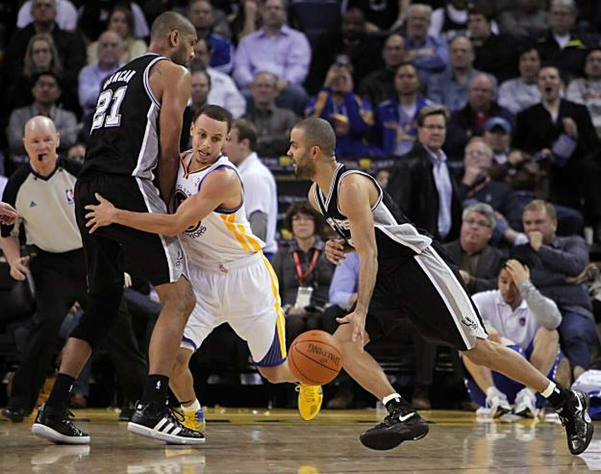 Stephen Curry is screened out by Tim Duncan as Tony Parker drives the lane in the fourth quarter at Oracle Arena in Oakland on Monday.