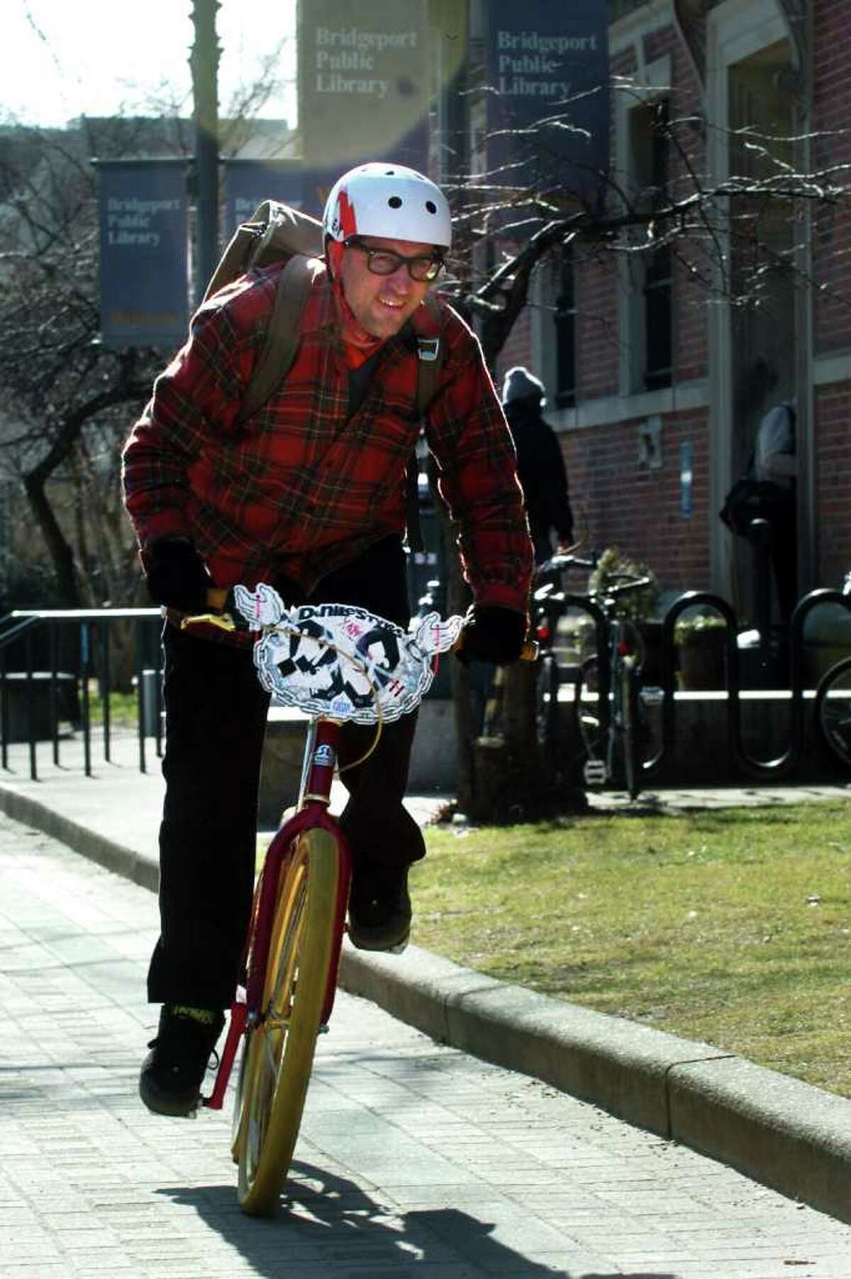 John Wilkins, of Bridgeport, rides his bicycle after returning books to the Burroughs & Saden Library in downtown Bridgeport, Conn. Feb. 10th, 2012.